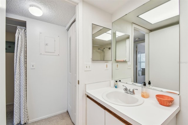 bathroom with vanity, electric panel, and a textured ceiling