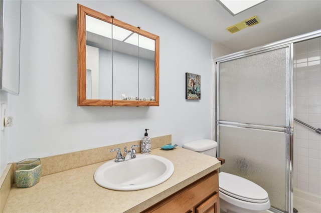 bathroom featuring vanity, an enclosed shower, and toilet