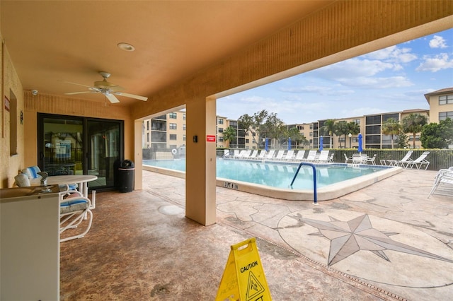 view of swimming pool featuring a patio and ceiling fan