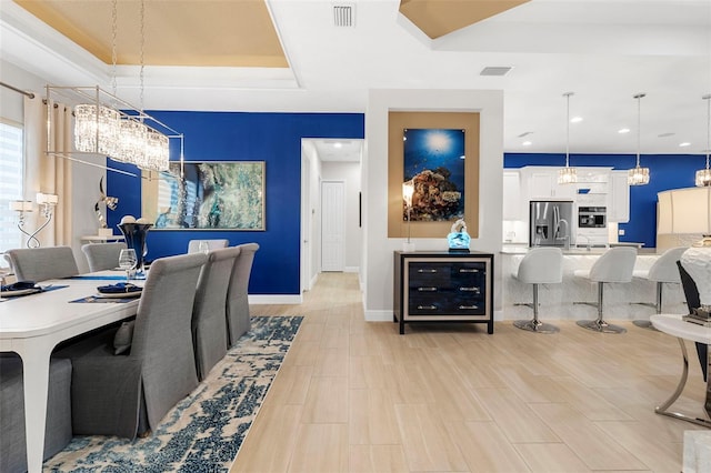 home office featuring a raised ceiling and an inviting chandelier