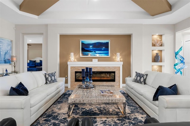 living room with a tiled fireplace and built in features