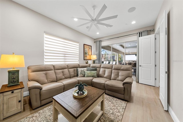 living room featuring ceiling fan and light hardwood / wood-style floors