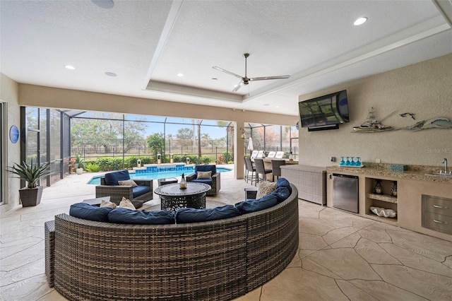 interior space featuring an outdoor kitchen, sink, a lanai, ceiling fan, and an outdoor living space