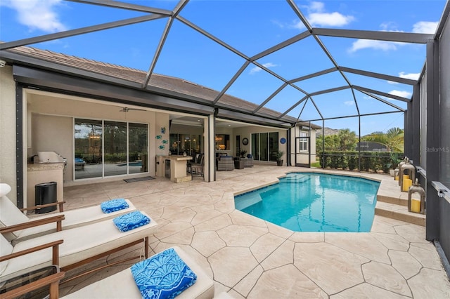 view of pool with a lanai, an outdoor bar, outdoor lounge area, a patio area, and area for grilling