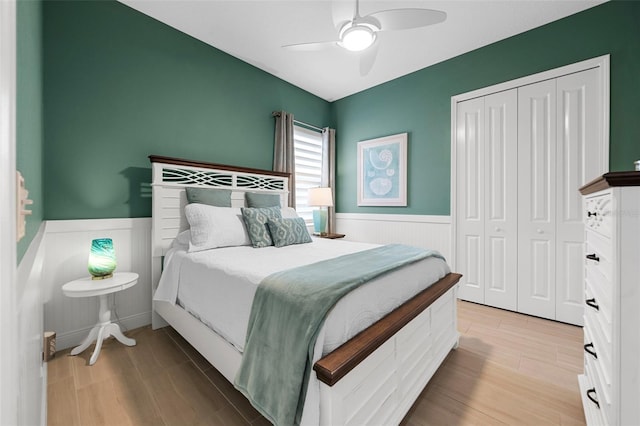 bedroom with light hardwood / wood-style floors, a closet, and ceiling fan