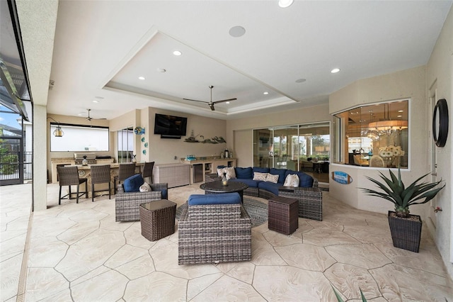 living room featuring ceiling fan and a tray ceiling