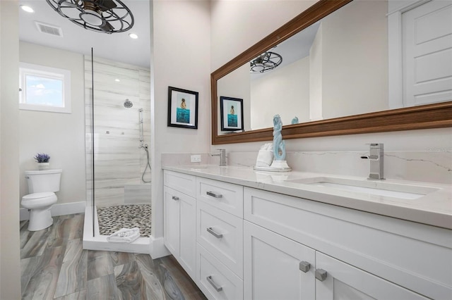 915 N Shore Dr, Anna Maria, FL 34216 - full bathroom with a sink, double vanity, toilet, visible vents, and a stall shower