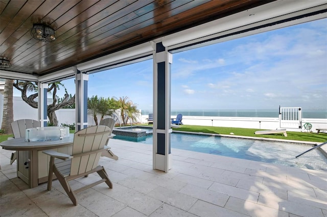915 N Shore Dr, Anna Maria, FL 34216 - view of pool featuring a fenced backyard, a water view, a pool with connected hot tub, and a patio area