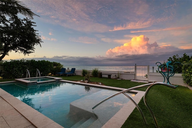 915 N Shore Dr, Anna Maria, FL 34216 - pool at dusk with a lawn, a water view, and a pool with connected hot tub
