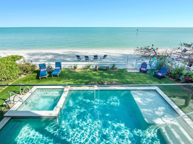 915 N Shore Dr, Anna Maria, FL 34216 - view of swimming pool featuring a beach view, a pool with connected hot tub, a yard, and a water view