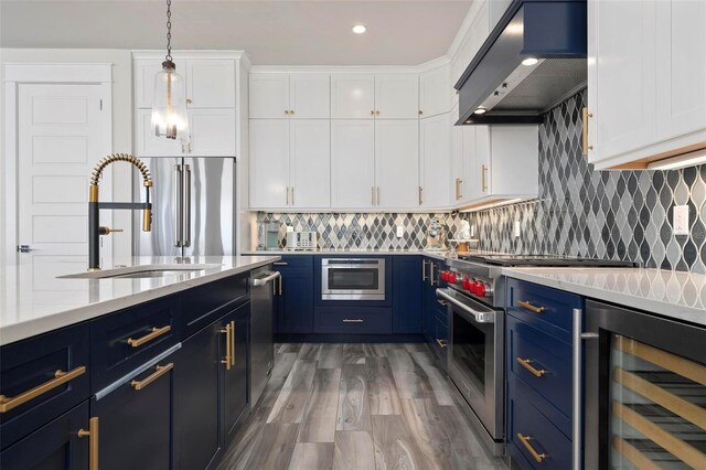 915 N Shore Dr, Anna Maria, FL 34216 - kitchen with exhaust hood, blue cabinetry, a sink, beverage cooler, and white cabinetry