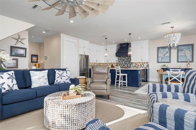 915 N Shore Dr, Anna Maria, FL 34216 - living room with light wood-style flooring, ceiling fan with notable chandelier, recessed lighting, baseboards, and visible vents