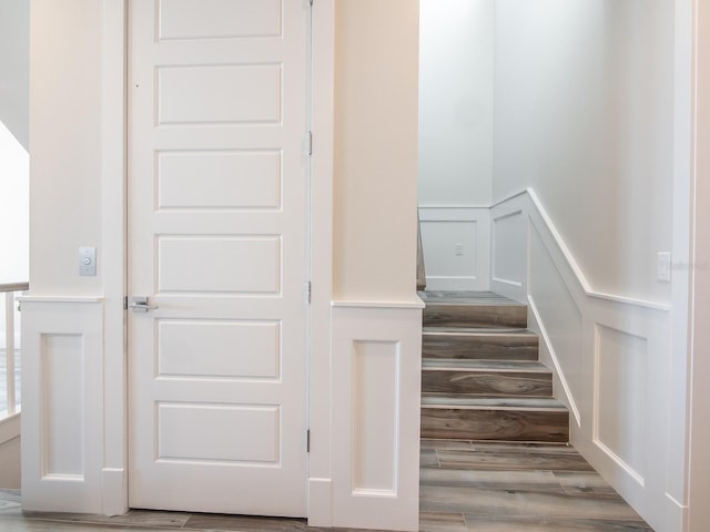 915 N Shore Dr, Anna Maria, FL 34216 - stairway with wood finished floors, a decorative wall, and a wainscoted wall