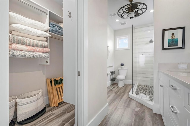 915 N Shore Dr, Anna Maria, FL 34216 - full bath with toilet, baseboards, a shower stall, wood finished floors, and visible vents