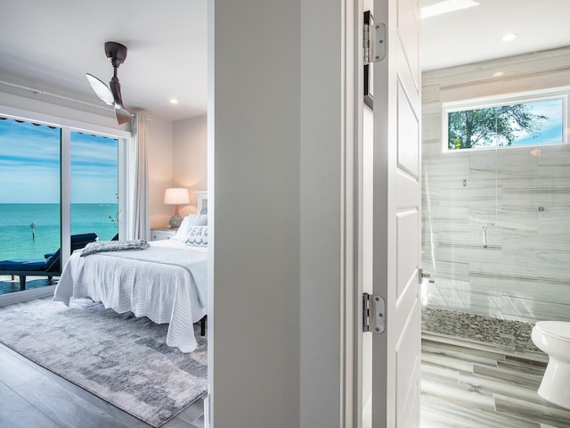 915 N Shore Dr, Anna Maria, FL 34216 - bedroom with recessed lighting, wood finished floors, a water view, and ensuite bath