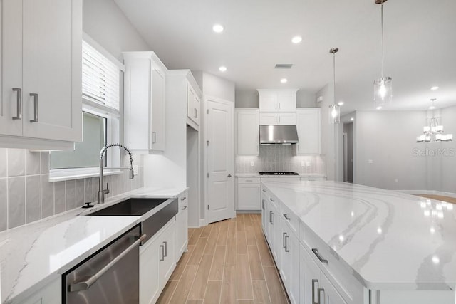 8024 Moonbeam Ave, Sarasota, FL 34241 - kitchen with dishwasher, under cabinet range hood, a sink, backsplash, and white cabinetry
