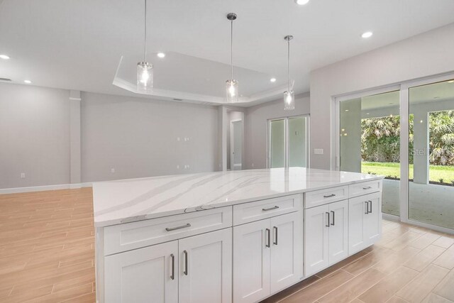 8024 Moonbeam Ave, Sarasota, FL 34241 - kitchen featuring white cabinetry, light wood-style flooring, pendant lighting, a raised ceiling, and recessed lighting