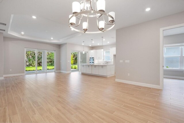 8024 Moonbeam Ave, Sarasota, FL 34241 - unfurnished living room with a chandelier, baseboards, light wood-style floors, and recessed lighting