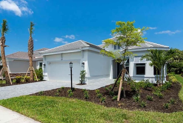 8024 Moonbeam Ave, Sarasota, FL 34241 - ranch-style house with decorative driveway, stucco siding, a garage, and a tiled roof