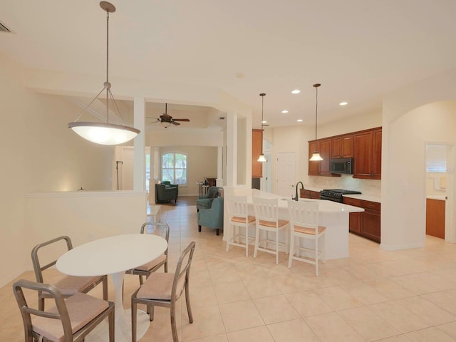 dining area featuring ceiling fan, sink, and light tile patterned floors