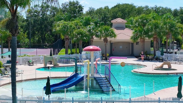 view of pool featuring a water slide, pool water feature, and a patio