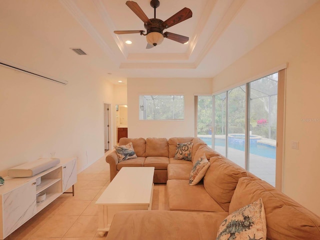 living room featuring crown molding, light tile patterned floors, ceiling fan, and a raised ceiling