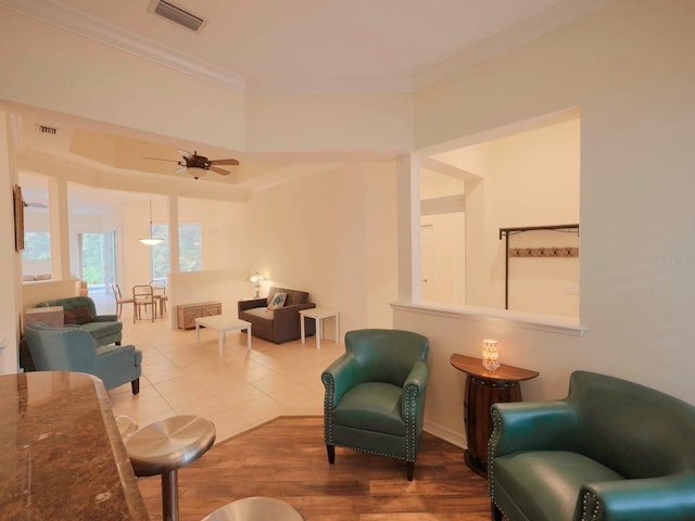 tiled living room featuring crown molding and ceiling fan