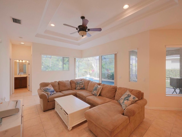 living room featuring light tile patterned floors, plenty of natural light, and a tray ceiling