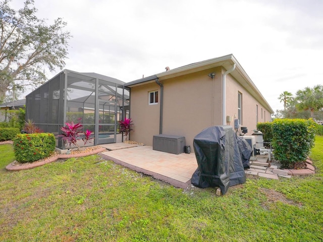 rear view of property featuring glass enclosure, a patio area, and a yard