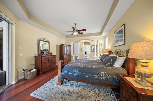 bedroom featuring ceiling fan, dark hardwood / wood-style flooring, and a raised ceiling