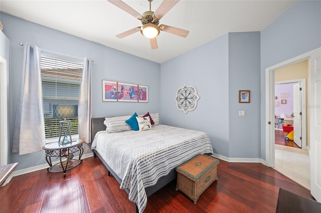 bedroom featuring ceiling fan, dark hardwood / wood-style flooring, and multiple windows