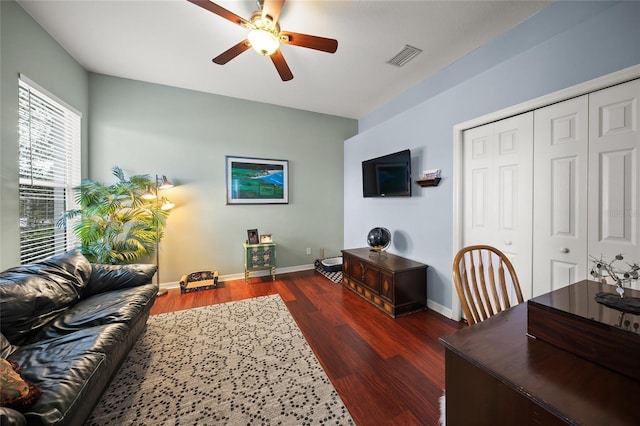 living room with ceiling fan and dark hardwood / wood-style flooring