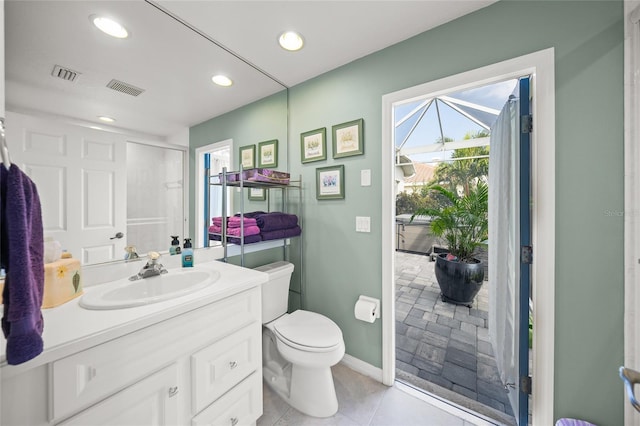 bathroom with toilet, a healthy amount of sunlight, a shower with shower door, and vanity