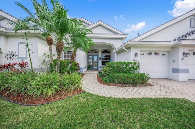 view of front of home featuring a garage, a front yard, and french doors