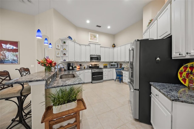 kitchen featuring sink, white cabinetry, appliances with stainless steel finishes, and kitchen peninsula