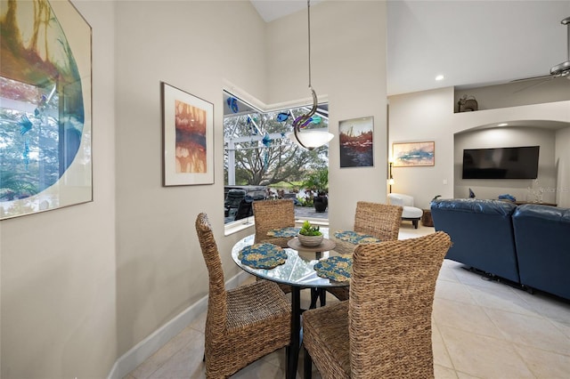 tiled dining area featuring a towering ceiling