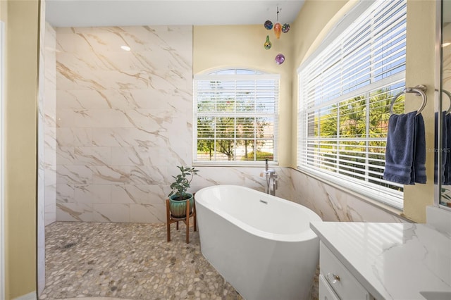 bathroom with tile walls, vanity, and plus walk in shower