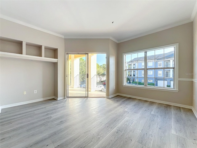 unfurnished room with light hardwood / wood-style floors and crown molding