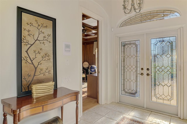 entrance foyer with french doors, coffered ceiling, beamed ceiling, and light tile patterned floors