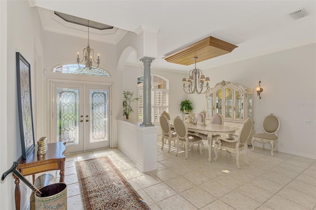 entryway with a chandelier, a raised ceiling, a wealth of natural light, and french doors