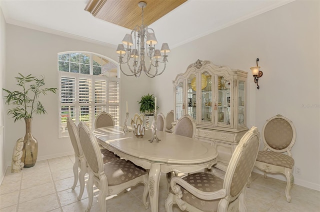 dining area featuring a notable chandelier, crown molding, and baseboards