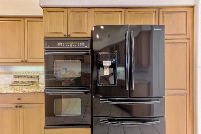 kitchen featuring light stone countertops, black appliances, and decorative backsplash