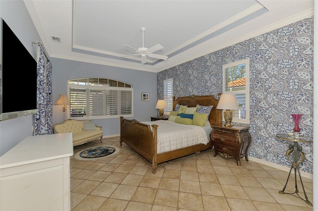 bedroom with visible vents, baseboards, ornamental molding, a tray ceiling, and wallpapered walls