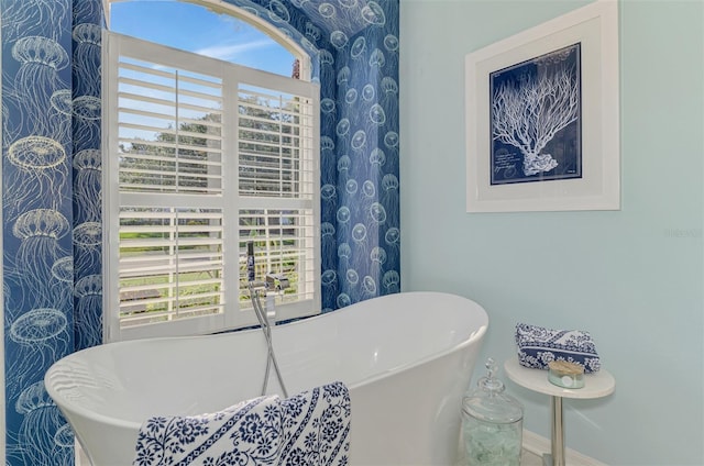 full bath with baseboards and a freestanding bath