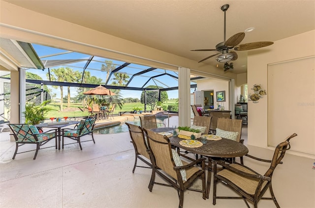 view of patio / terrace featuring a ceiling fan, outdoor dining space, glass enclosure, and an outdoor pool