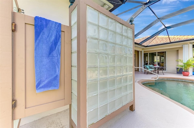 view of swimming pool with glass enclosure and a patio area