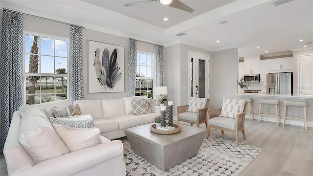 living room featuring ceiling fan, light hardwood / wood-style flooring, and crown molding