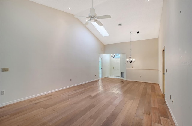 unfurnished living room featuring ceiling fan with notable chandelier, light hardwood / wood-style floors, and high vaulted ceiling