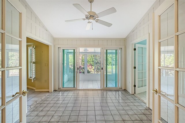 unfurnished sunroom featuring ceiling fan, lofted ceiling, and french doors