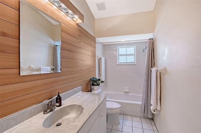 full bathroom with toilet, vanity, tile patterned floors, wood walls, and shower / bathtub combination with curtain